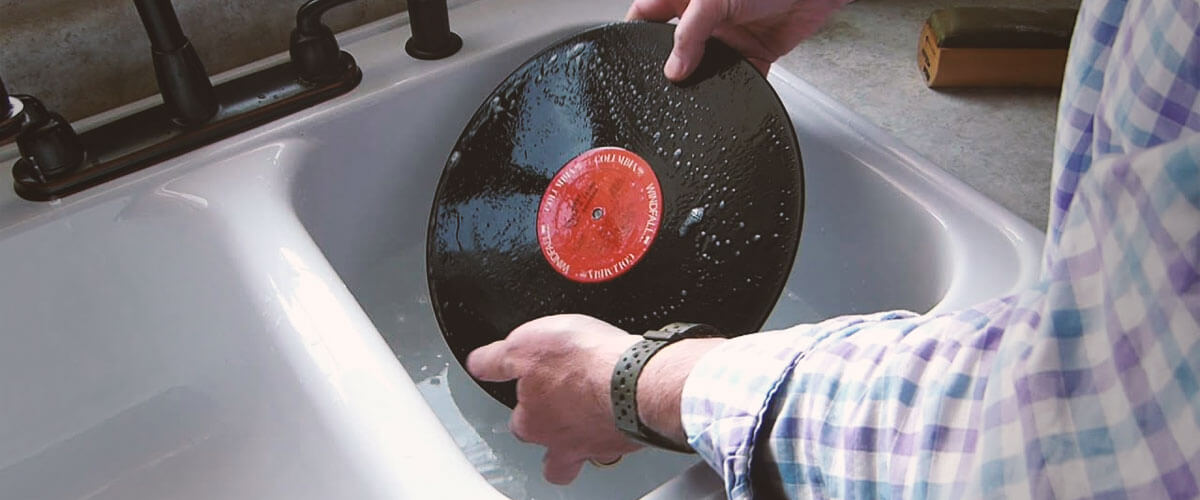 Can I clean my vinyl records using soap and water?